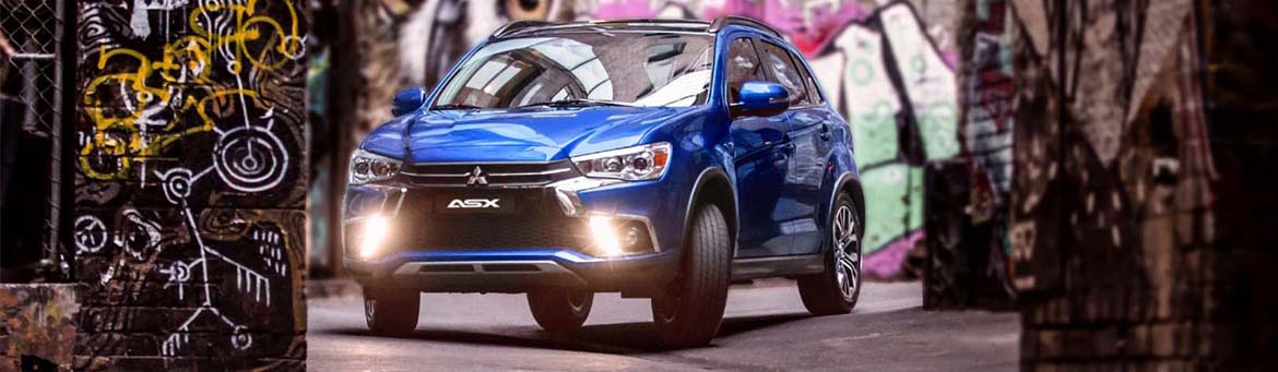 Couple standing next to a new Mitsubishi ASX in silver.