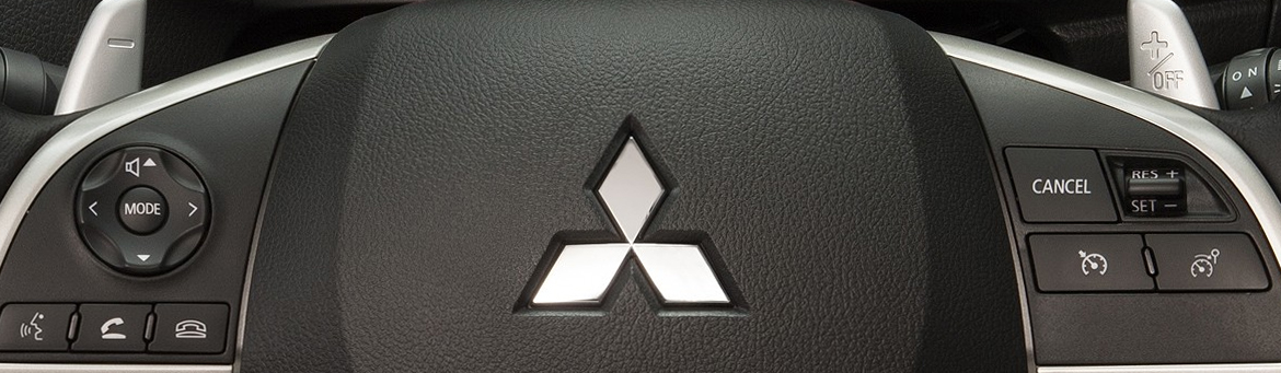 Close up of a Mitsubishi multi-function steering wheel and gear shift paddles.