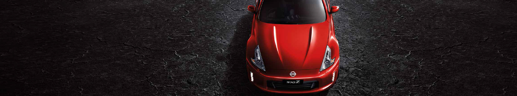 Top view of a Nissan 370Z Coupe in Eau Rouge Red on a grey background.