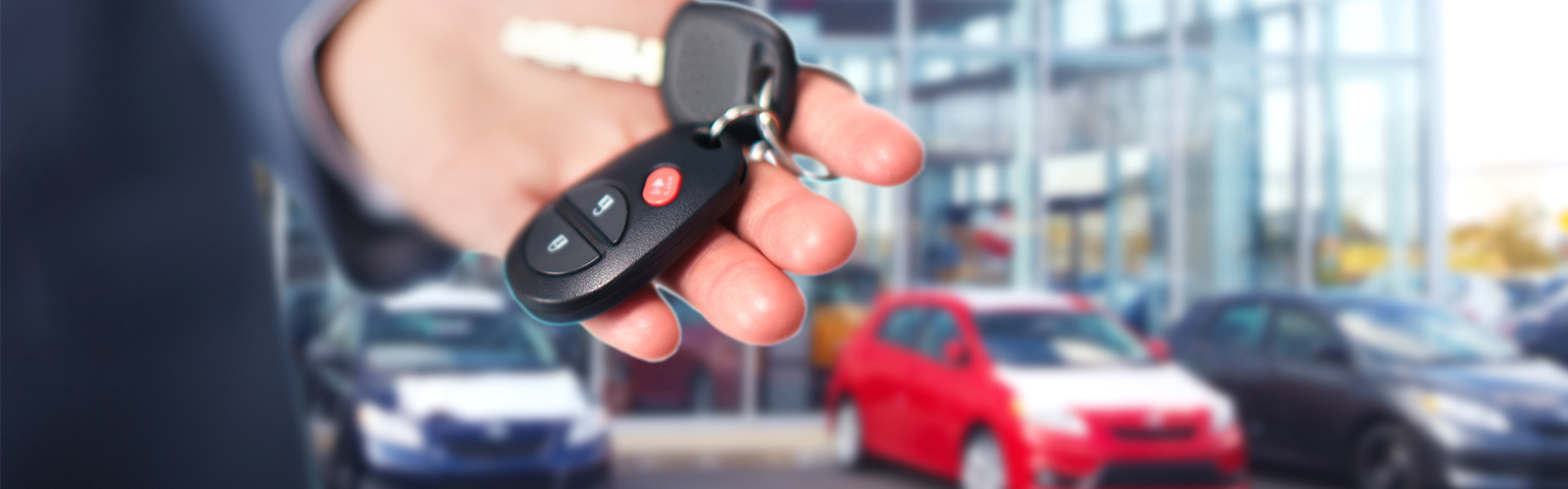 Salesman holding the keys to a used car at Metro Used Cars in Brisbane.