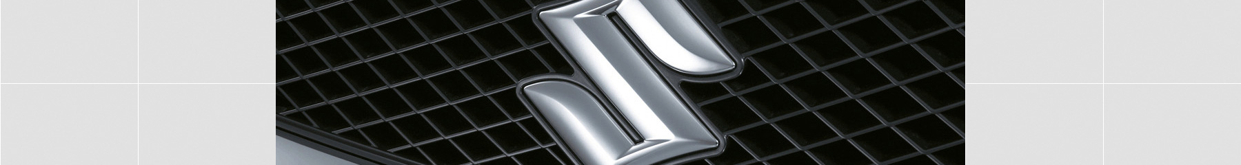 Close up of the Suzuki emblem on the grille of a Suzuki Swift hatch.