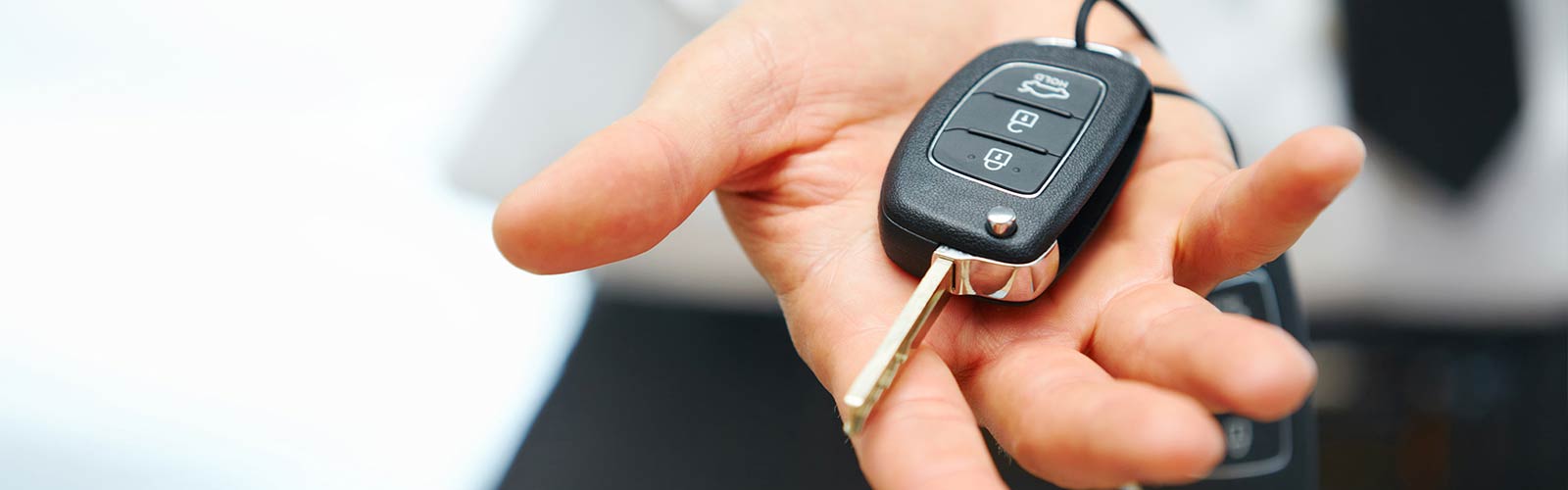 Person holding the keys to a new car in the palm of their hand.
