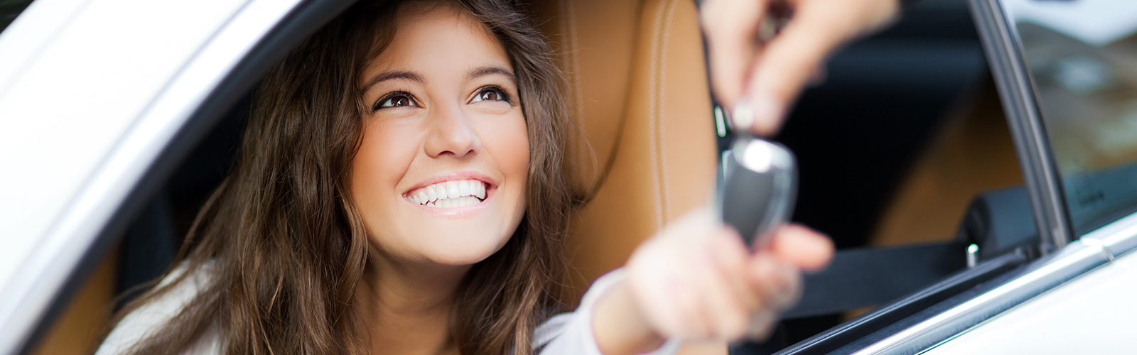 Smiling girl getting the keys to her new car at Metro Used Cars In Brisbane.